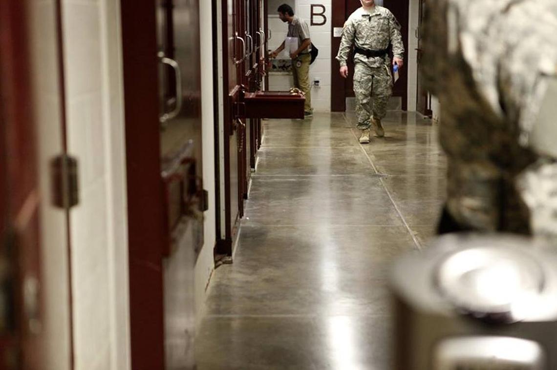 An International Committee of the Red Cross delegate shakes hands with a detainee through a slot in his cell door.