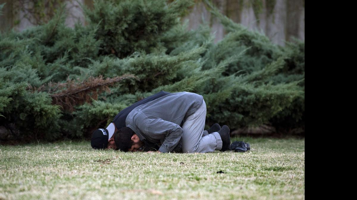 
Former Guantánamo inmates Syrian Abd al Hadi Omar Mahmoud Faraj, front, and Tunisian Abdul Bin Muhammad Abbas Ouerghi, pray in front of US embassy in Montevideo, Uruguay, on April 25, 2015. ]
