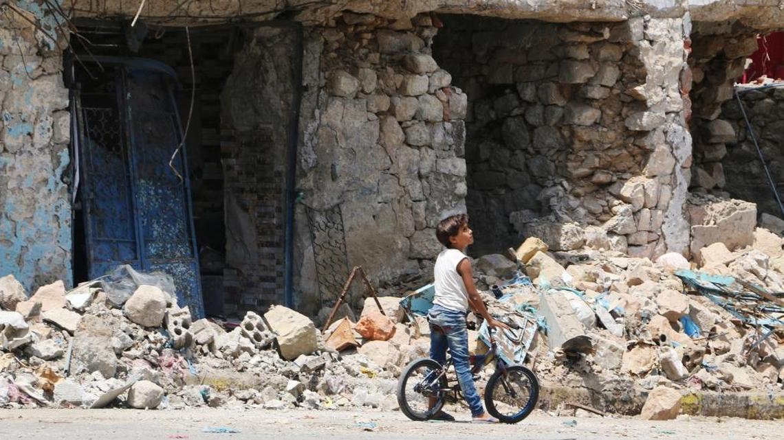 
A boy with his bicycle stands near buildings destroyed during fighting between tribal fighters and Shiite rebels known as Houthis at a street in Taiz, Yemen, Aug. 23, 2015. Yemen's conflict pits the Iran-allied Houthis and troops loyal to the former president, Ali Abdullah Saleh, against an array of forces including southern separatists, local and tribal militias, Sunni Islamic militants as well as troops loyal to President Abed Rabbo Mansour Hadi. 
