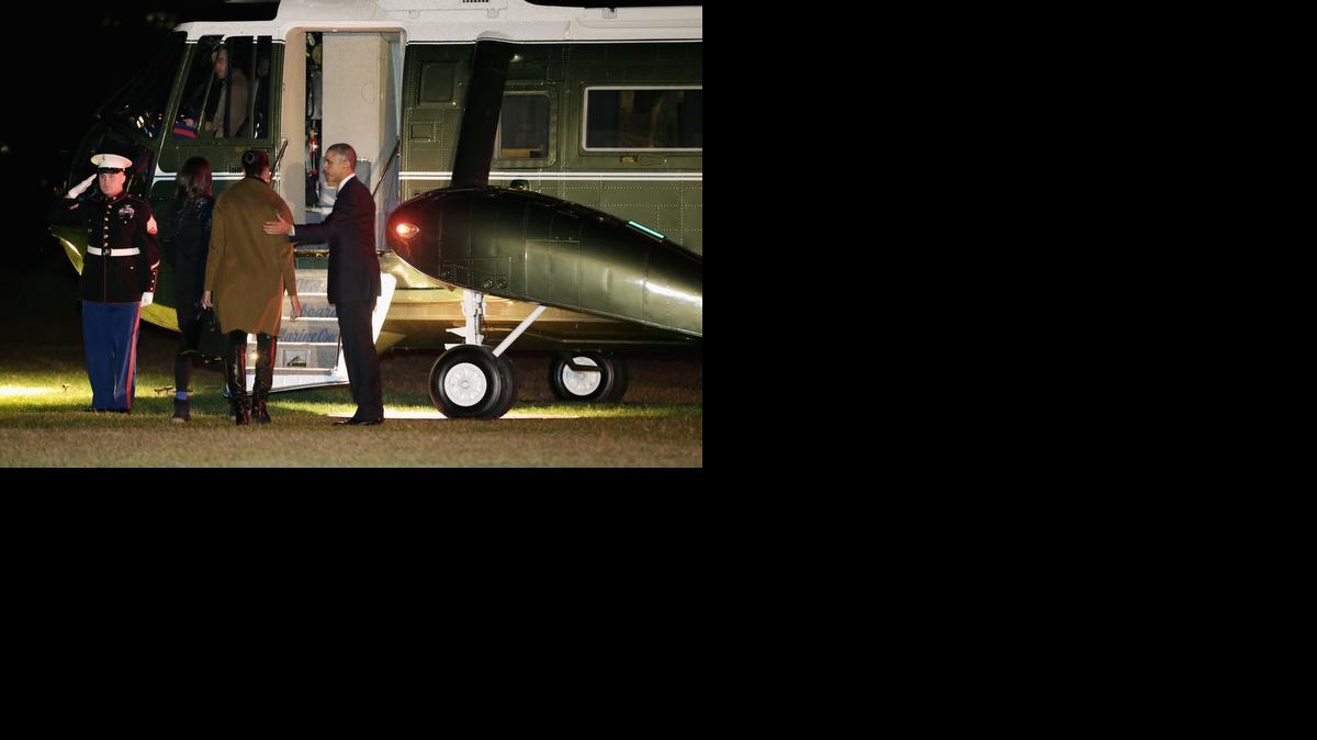 
President Barack Obama, right, first lady Michelle Obama center and their daughter Malia board Marine One before leaving the White House for their holiday vacation Dec. 19, 2014 in Washington, D.C. 

