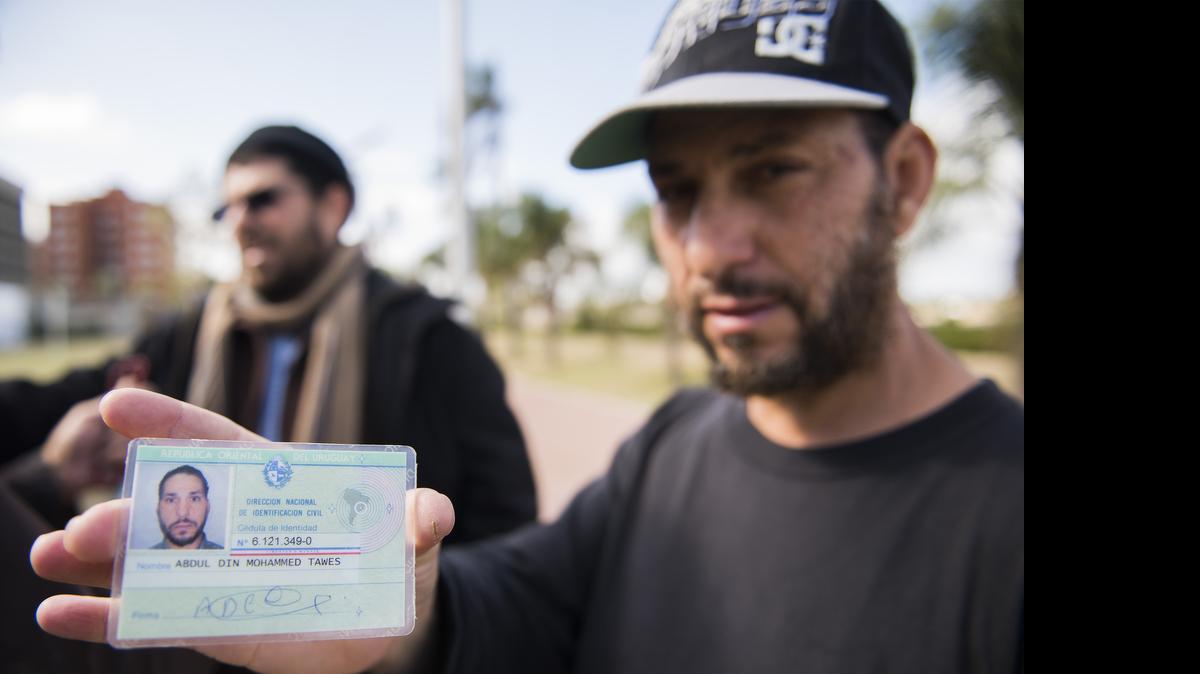 
Freed Guantanamo Bay detainee Adel bin Muhammad El Ouerghi, of Tunisia shows his Uruguayan identification card May 6, 2015 in front of the U.S. Embassy in Montevideo, Uruguay. 
