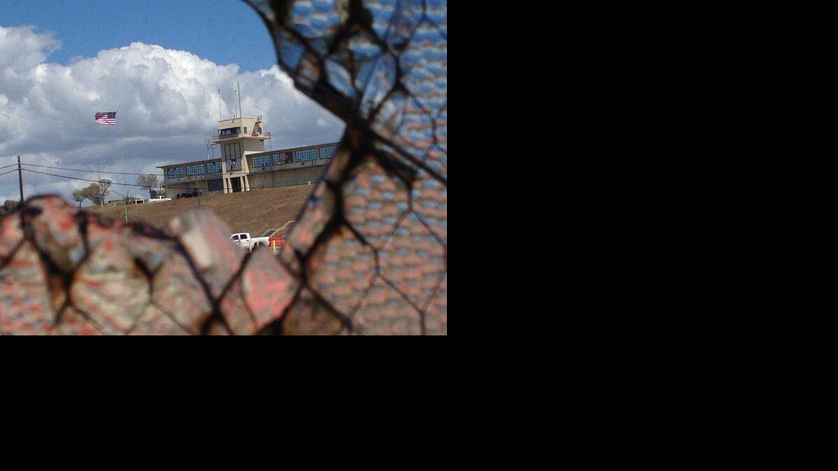 
The flag flying over the war court complex, Camp Justice, as seen through a broken window at an abandoned air hangar at the U.S. Navy base at Guantánamo Bay, Cuba, on Feb. 28, 2015, in an image approved for release by the U.S. military.
