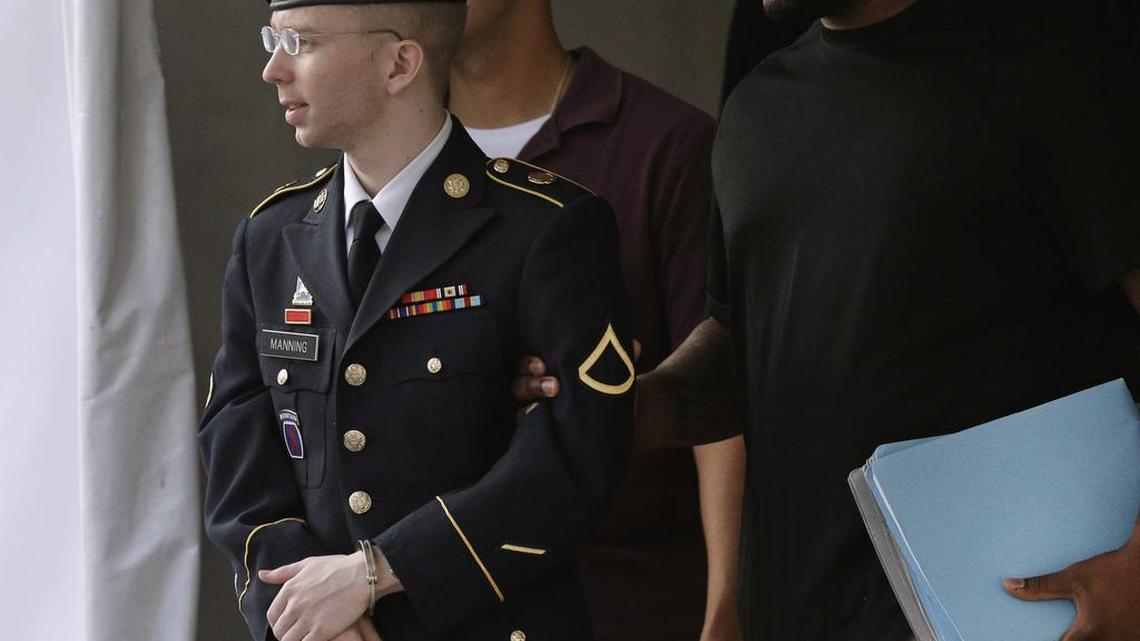 Army Pfc. Bradley Manning, left, is escorted to a security vehicle outside a courthouse in Fort Meade, Md., on July 18, 2013, after his court-martial judge, Col. Denise Lind, refused a defense request to dismiss a charge that Manning aided the enemy by giving reams of classified information to the anti-secrecy website WikiLeaks.