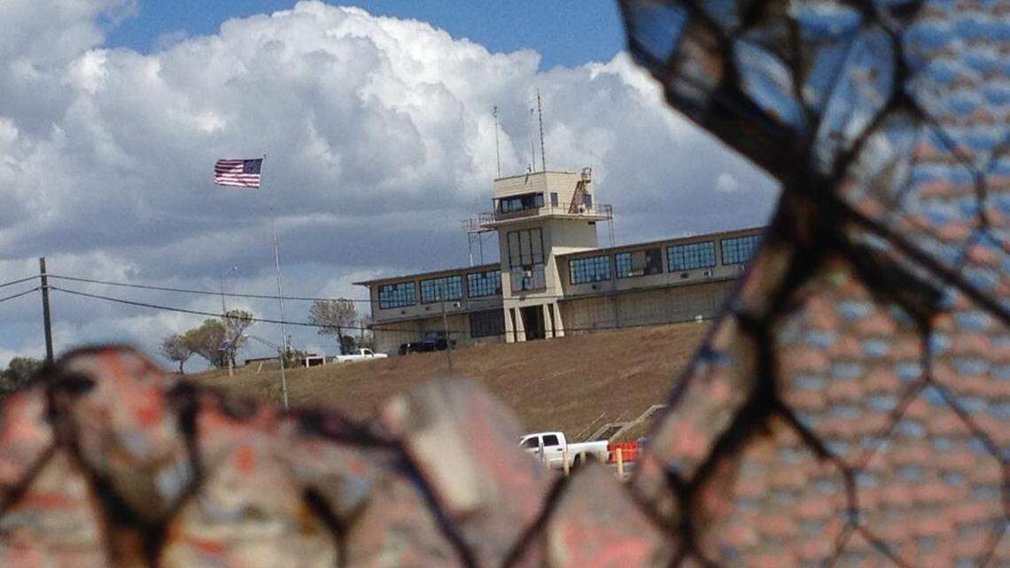 The flag flying over a portion of the war court complex, Camp Justice, as seen through a broken abandoned air hangar window at the U.S. Navy base at Guantánamo Bay, Cuba, on Feb. 28, 2015, in an image approved for release by the U.S. military.