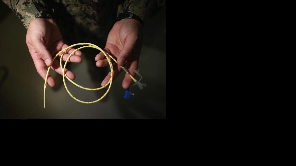 
A Navy doctor holds a feeding tube used to deliver a can of Ensure up the nose and down the back of the throat and into the stomach of a prison camp hunger striker on June 26, 2013 at the U.S. Navy base at Guantánamo Bay, Cuba.
