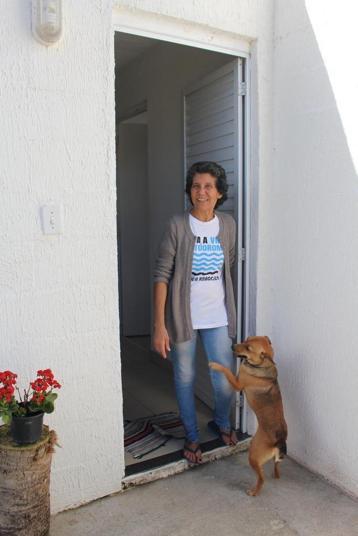 Maria da Penha with her adopted dog Nina. The dog’s first two families moved out of the community as it was being razed to make way for Olympics construction.