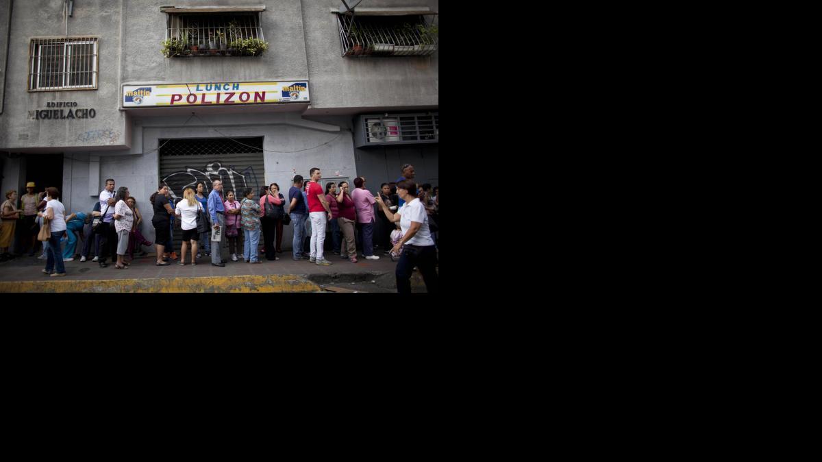 
People wait in line to enter a small market to try to buy items like disposable diapers, laundry detergent and razors in downtown Caracas, Venezuela, Thursday, Oct. 23, 2014. The falling oil prices that are providing relief to drivers around the world threaten to bring more misery to the life of millions of Venezuelans, whose country depends almost exclusively on oil revenue. 
