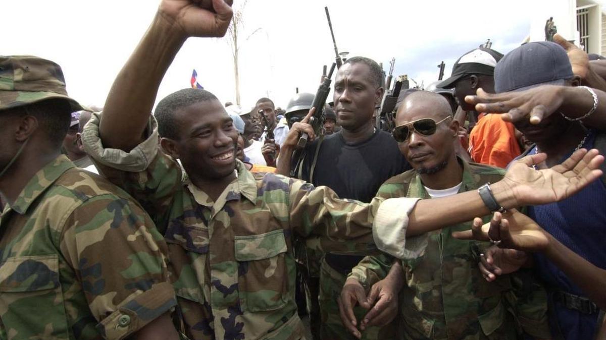 A 2002 photo shows Guy Philippe (far left), one of the rebel leaders of the Resistance Front, in Gonaives after an armed revolt.