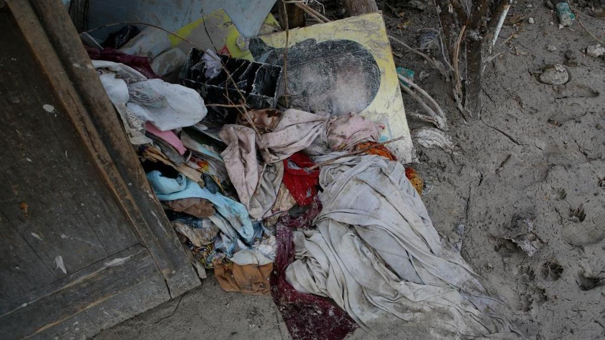 A water-damaged campaign poster lies amidst clothes and other household goods outside a home destroyed by Hurricane Matthew in a seaside fishing neighborhood of Port Salut, Haiti, Sunday, Oct. 9, 2016. Oct. 9 was the date set for Haiti's presidential elections, but they were postponed after Hurricane Matthew.