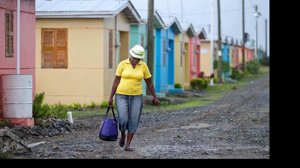 
Signs of progress: A woman walks through the Caracol-EKAM housing development built by the U.S. Agency for International Development. 
