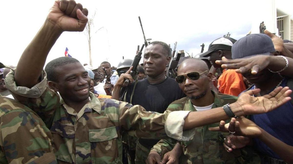 A 2002 photo shows Guy Philippe (far left), one of the rebel leaders of the Resistance Front, in Gonaives after an armed revolt.