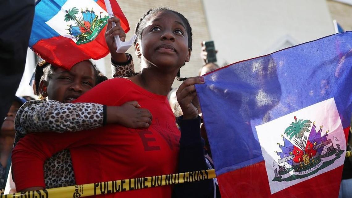 Protesters gather at President Trump’s Mar-a-Lago resort on Monday, Jan. 15, in response to reports that the president called Haiti, Africa and El Salvador “shithole countries.”