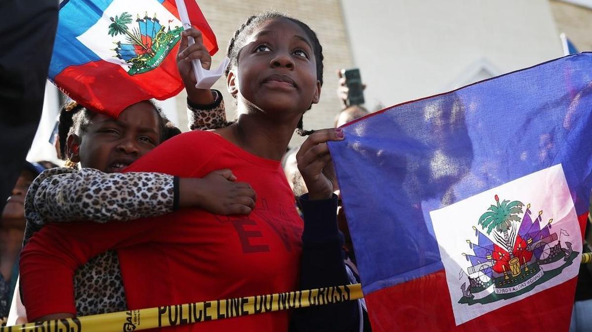 Protesters gather at President Trump’s Mar-a-Lago resort on Monday, Jan. 15, in response to reports that the president called Haiti, Africa and El Salvador “shithole countries.”
