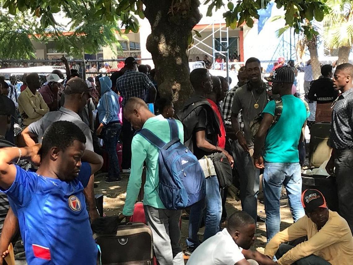 Chile-bound Haitians wait in a park across the street from Toussaint Louverture International Airport in Port-au-Prince, Haiti in October. That month 13,000 Haitians traveled to Haiti.
