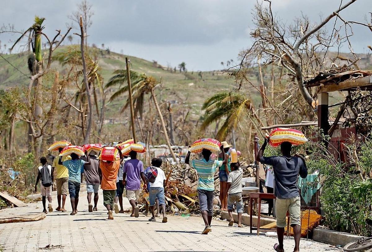 Haitians head back to their destroyed homes in southern Haiti after receiving donations of rice after Hurricane Matthew struck the country’s southern peninsula in October 2016.
