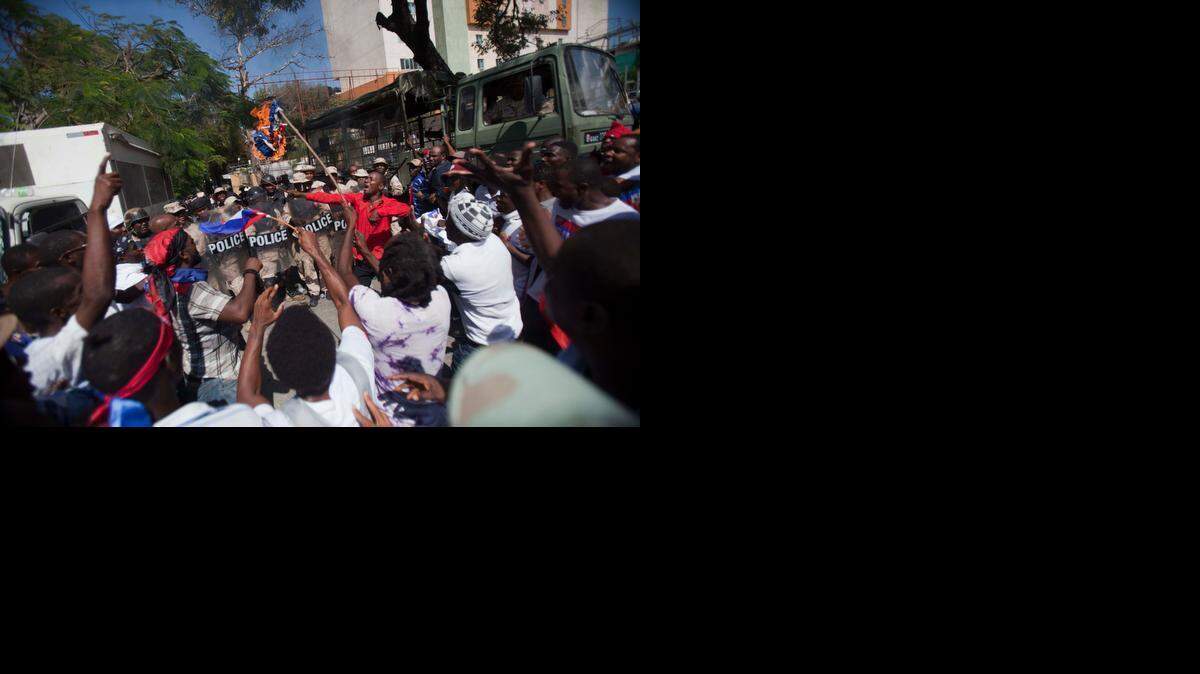 
Protesters burn a Dominican flag in front of the country's consulate during an anti-Dominican Republic protest in Port-au-Prince, Haiti, Wednesday, Feb. 25, 2015. Protesters outraged over a Feb. 11 lynching of a young man of Haitian descent in the Dominican city of Santiago are demanding the neighboring country respect the human rights of Haitians. 


