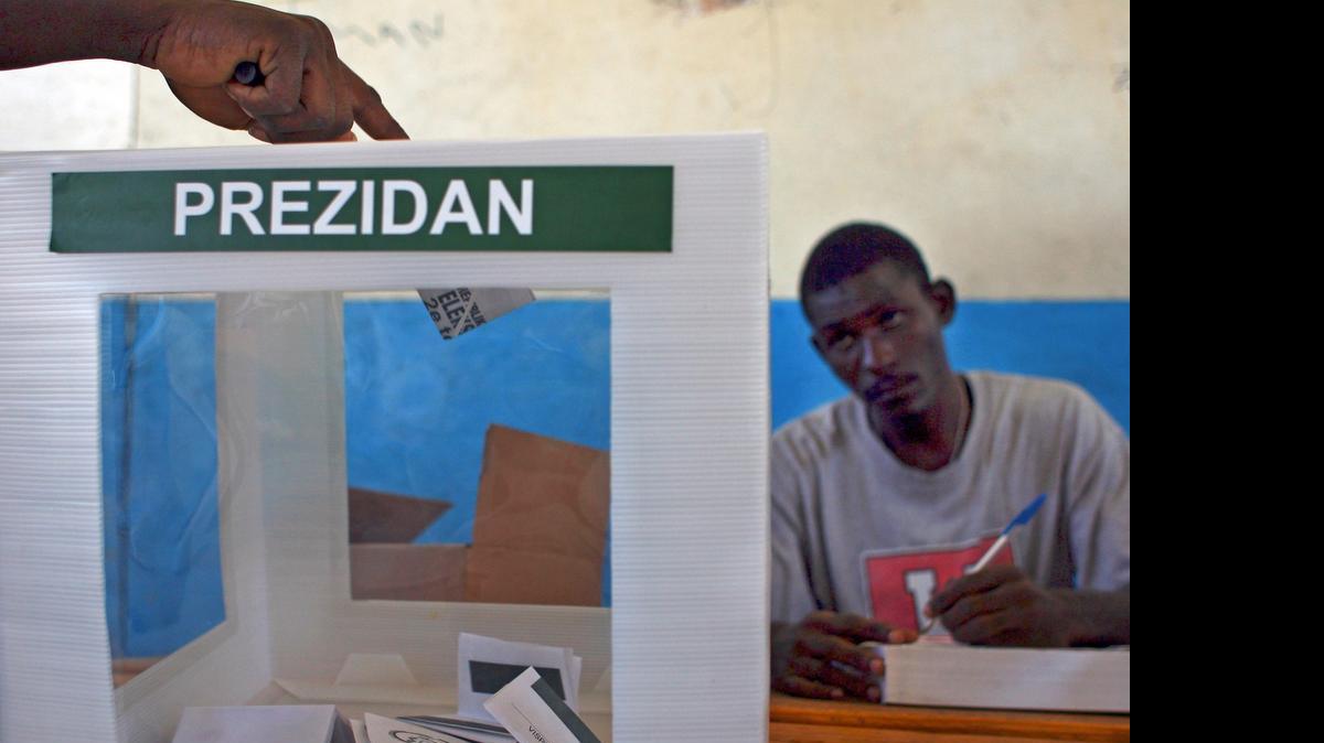 
A voter puts a ballot in the box during the election in Cite Soleil, Haiti March 20, 2011. 
