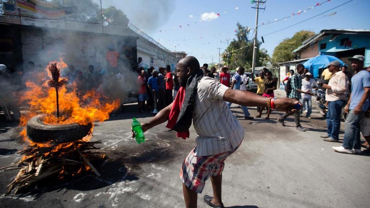 A demonstrator performs a Vodou ceremony at the start of a rally supporting Senate President Jocelerme Privert for interim president in Port-au-Prince, Haiti, Friday, Feb. 12, 2016. Supporters of the Lavalas political party rallied for the Senate leader to become Haiti's interim president to fill the void left by twice postponed presidential and legislative runoffs and departure of President Michel Martelly.