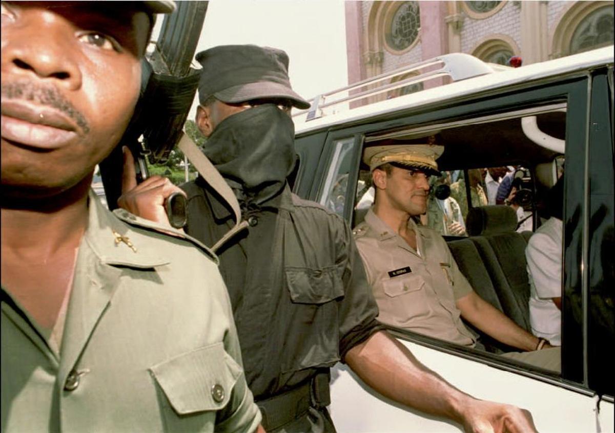 Surrounded by heavy security, Haitian Army Chief Gen. Raoul Cedras sits in his car moments after attending a mass for peace in Haiti at the cathedral of Port-Au-Prince Aug. 15, 1994. Gen. Cedras repeatedly said he would not step down from power and that his army would fight against a possible U.S. military invasion of Haiti.