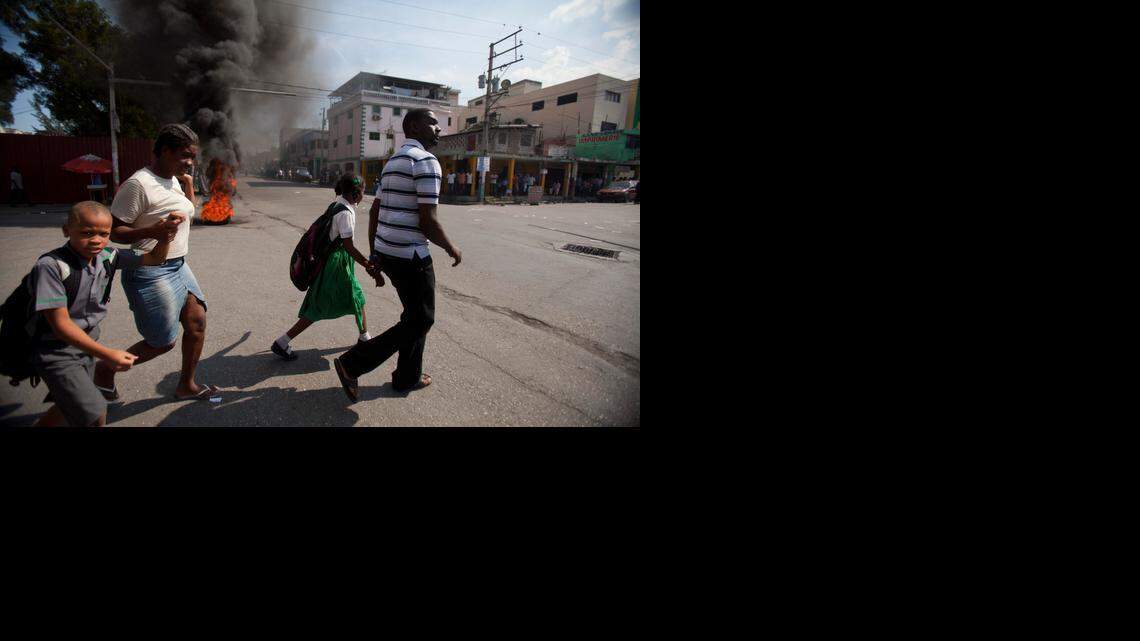 
Parents pull their children out of school early due to an anti-government protest that got violent in Port-au-Prince, Haiti, Friday, Dec. 12, 2014. United Nations peacekeepers fired at a crowd of protesters who were demanding new leadership just days after a government-appointed commission recommended that the country's prime minister resign. 
