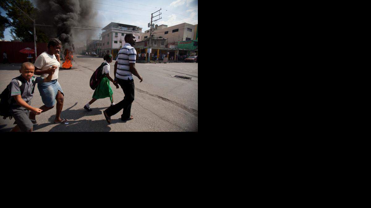 
Parents pull their children out of school early due to an anti-government protest that got violent in Port-au-Prince, Haiti, Friday, Dec. 12, 2014. United Nations peacekeepers fired at a crowd of protesters who were demanding new leadership just days after a government-appointed commission recommended that the country's prime minister resign. 
