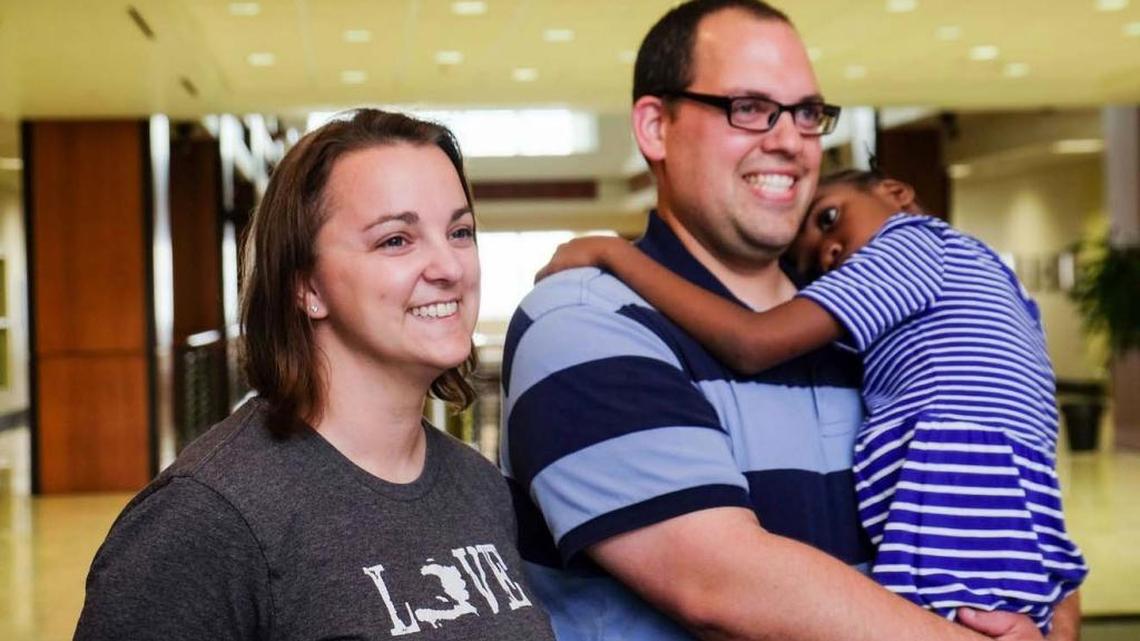 Dan Cruz holds 7-year-old Angelene while visiting the U.S. embassy in Port-au-Prince on Friday. He and wife Julie became the first American couple to adopt a Haitian child under the country’s new international regulations.