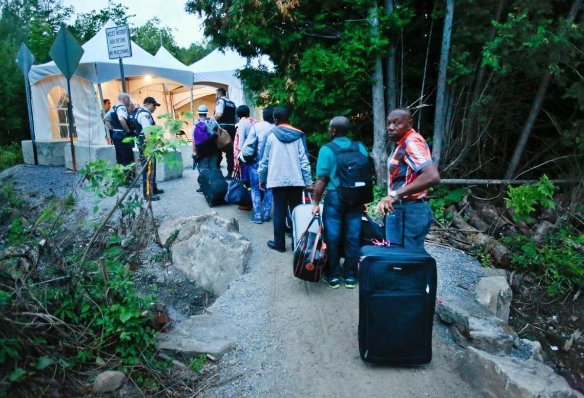 Haitian migrants living in the United States prepare to cross the U.S. and Canadian border along Roxham Road on August 11, 2017. Thousands of Haitians had crossed over in to Canada from an irregular crossing near the Champlain-Saint-Bernard-de-Lacolle border in hopes of finding residency in Canada.