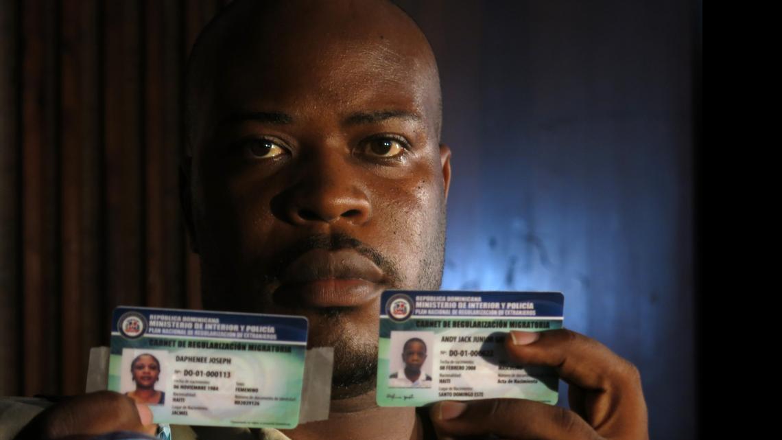 
Haitian migrant Jackner Gilot poses with his new credentials and those of his family, which allows them to live and work in the Dominican Republic for two years as “non-resident’’ foreigners, in Santo Domingo, Dominican Republic, Monday, July 6, 2015. A group of 260 people were the first foreigners to receive the credentials. More than 288,000 foreigners, mostly Haitians, applied during the last year for a temporary resident permit, trying to avoid deportation. 
