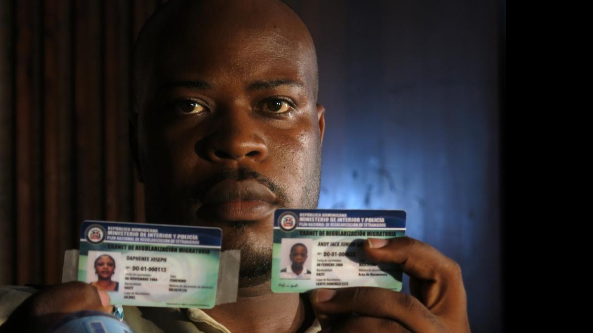 
Haitian migrant Jackner Gilot poses with his new credentials and those of his family, which allows them to live and work in the Dominican Republic for two years as “non-resident’’ foreigners, in Santo Domingo, Dominican Republic, Monday, July 6, 2015. A group of 260 people were the first foreigners to receive the credentials. More than 288,000 foreigners, mostly Haitians, applied during the last year for a temporary resident permit, trying to avoid deportation. 
