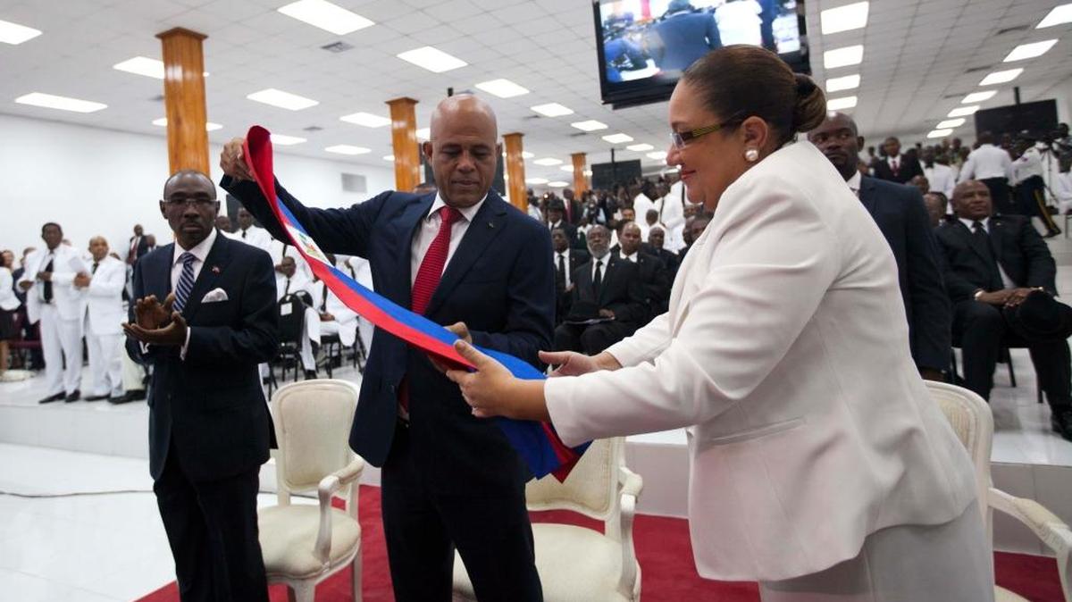 Former Haiti President Michel Martelly and wife Sophia work together to fold thepresidential sash after he delivered his farewell speech at Parliament in Port-au-Prince, Haiti, Sunday, Feb. 7, 2016. Martelly left office Sunday with no leader yet chosen to fill the void left by his departure.