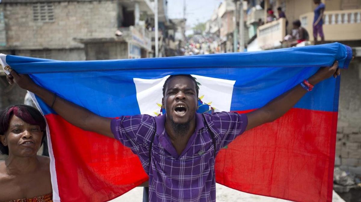 A supporter of presidential candidate Maryse Narcisse marches with a Haitian national flag during a demonstration in support of interim President Jocelerme Privert in Port-au-Prince, Haiti, on June 14. Haiti's legislators will decide whether to pave way for a new interim leader until elections can be resolved or extend the temporary term for Privert.
