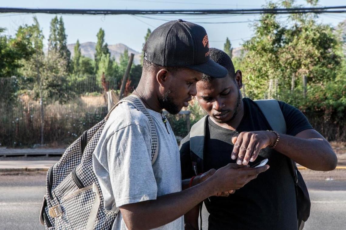 Benissont Joseph, 28, and Jean Wilgens, 27, are among a line of migrants who stake out a busy country road in Colina, Chile, every morning in search of a day laborer’s gig. They are among an influx of young Haitians who have migrated to the country in the past year in search of work and a better life.