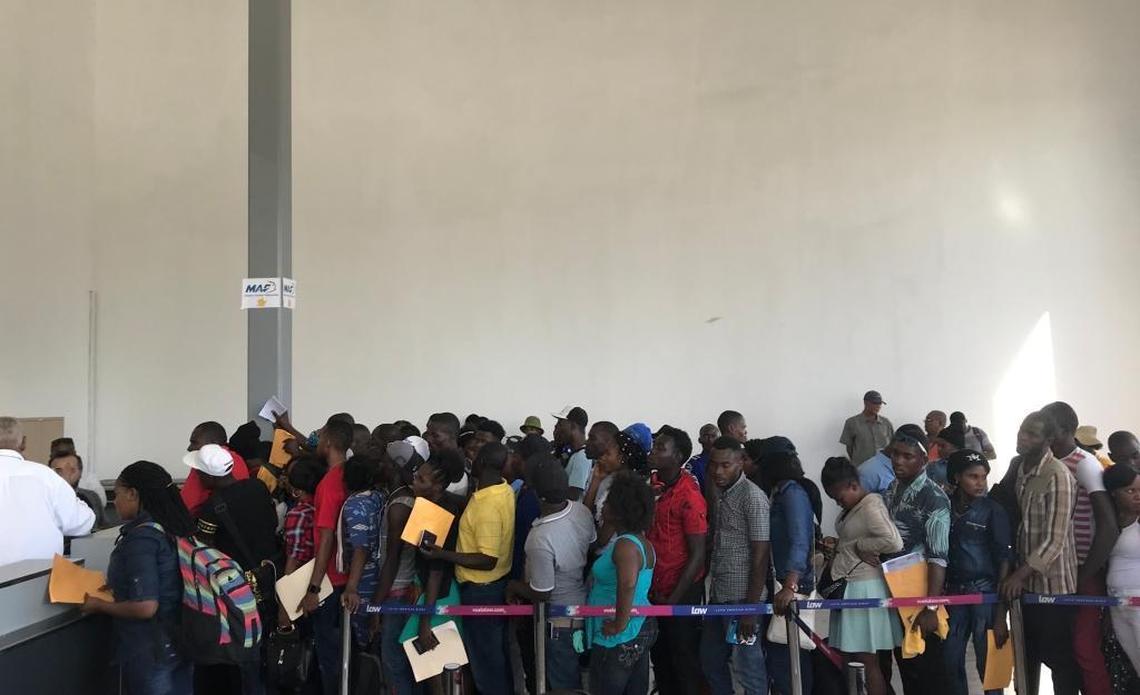 Passengers at Haiti’s domestic airport wait to check-in for a Chile-bound flight in February. Many of those rushing to get to the South American country lately are middle-class, educated youth said the manager of one of the airlines.