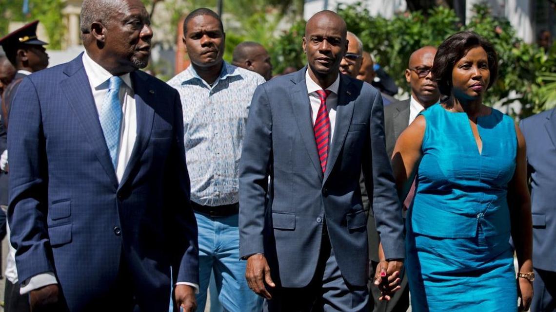 Haiti's President Jovenel Moïse,, center, walks with first lady Martine Moïse, and his Defense Minister Herve Denis, left, during a ceremony presenting the leadership of the newly reinstated Haitian Armed Forces (FAd'h) in Port-au-Prince, Haiti, Tuesday, March 27, 2018.