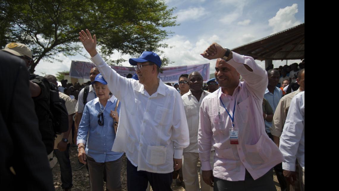 
U.N. Secretary-General Ban Ki-moon, center wearing blue cap, and then Haitian Prime Minister Laurent Lamothe, right, greet residents during the launching of sanitation campaign in Hinche, Haiti, Monday, July 14, 2014. The Secretary-General arrived in rural Haiti to help launch a program to improve sanitation and fight the spread of cholera, a disease that many Haitians blame U.N. peacekeepers for introducing to the impoverished Caribbean country. 
