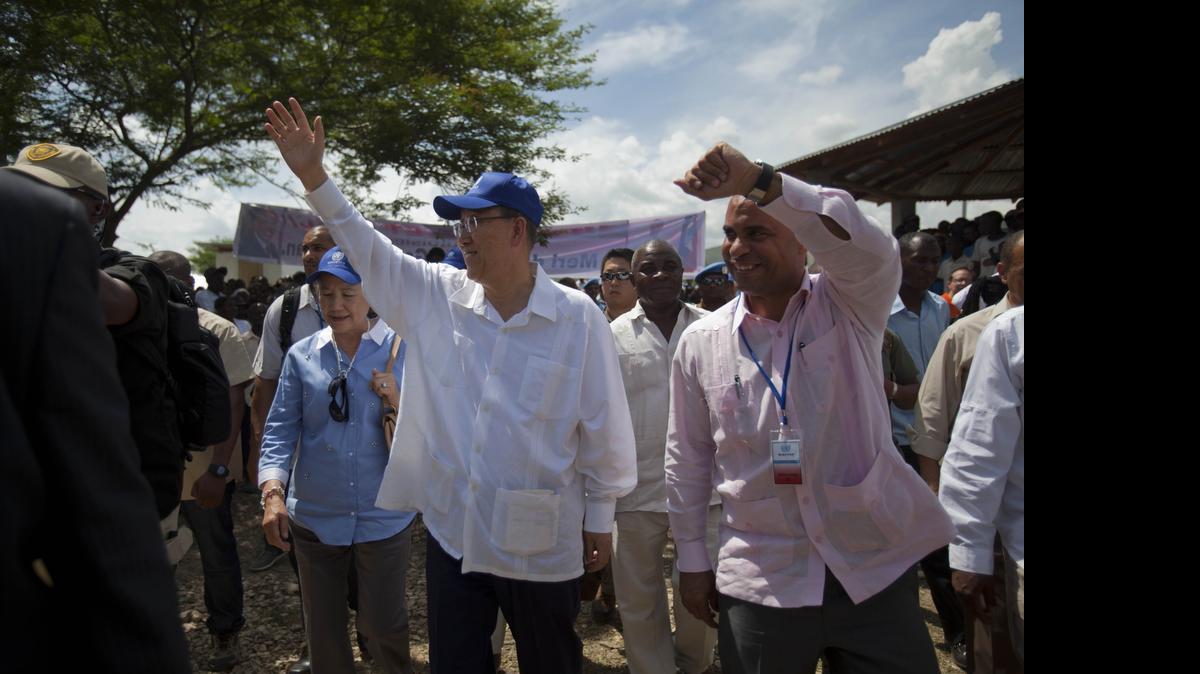 
U.N. Secretary-General Ban Ki-moon, center wearing blue cap, and then Haitian Prime Minister Laurent Lamothe, right, greet residents during the launching of sanitation campaign in Hinche, Haiti, Monday, July 14, 2014. The Secretary-General arrived in rural Haiti to help launch a program to improve sanitation and fight the spread of cholera, a disease that many Haitians blame U.N. peacekeepers for introducing to the impoverished Caribbean country. 
