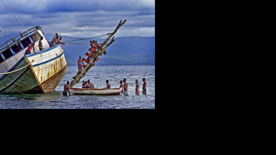 
Workers off the beach in the village of Basse-Terre along the southeastern coast of Île de la Tortue in the northwest region of Haiti attempt to fix a damaged boat in early October 2014.
