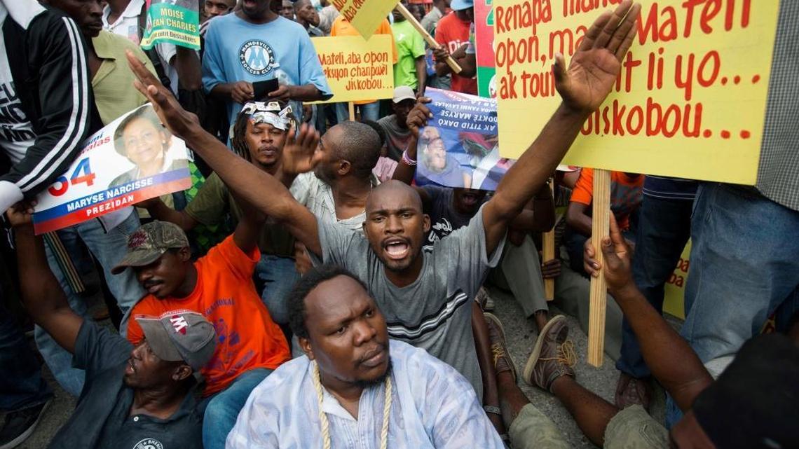 Demonstrators chant anti-electoral council slogans during a protest against the country’s electoral council to mark the 25th anniversary of first democratic election in 1990, in Port-au-Prince on Dec. 16. Disputed election results have brought a renewed surge of paralyzing street protests and many broad accusations of electoral fraud from civil society and opposition groups.