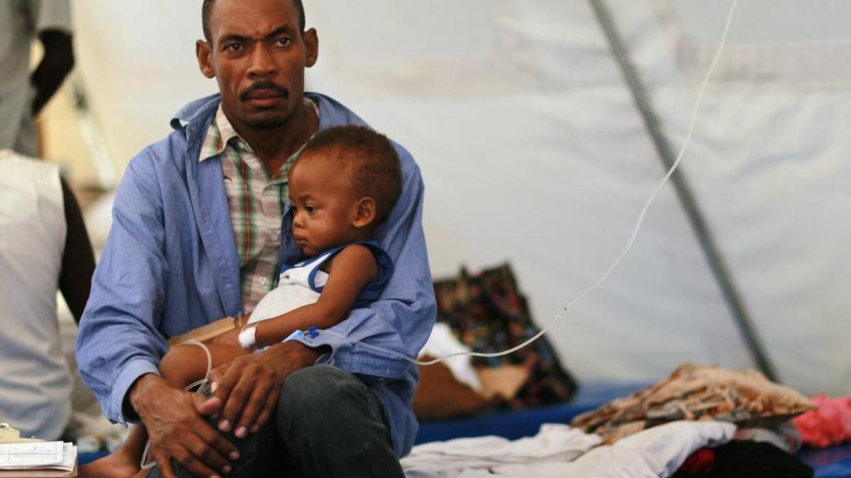 Theophil Gilot holds his son, Alexendro Gilot as the boy is being treated for cholera in a Samaritan's Purse cholera treatment facility on November 24, 2010 in Cabaret, Haiti. Haiti continues to deal with a cholera epidemic.