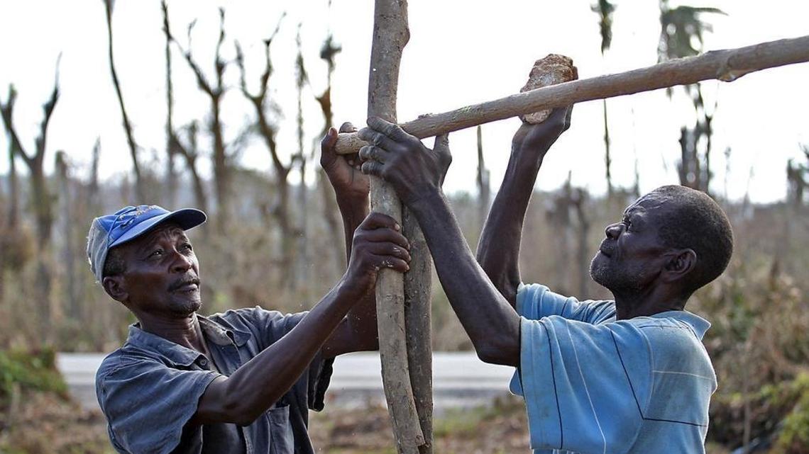 Jeremie, Haiti. Jean Lamar and Marcorel Nicola build a tent for shelter outside of Jeremie, Haiti on Monday, October 10, 2016. Lamar lost an 18-year-old son during Hurricane Matthew and Nicola also lost two children during the storm .