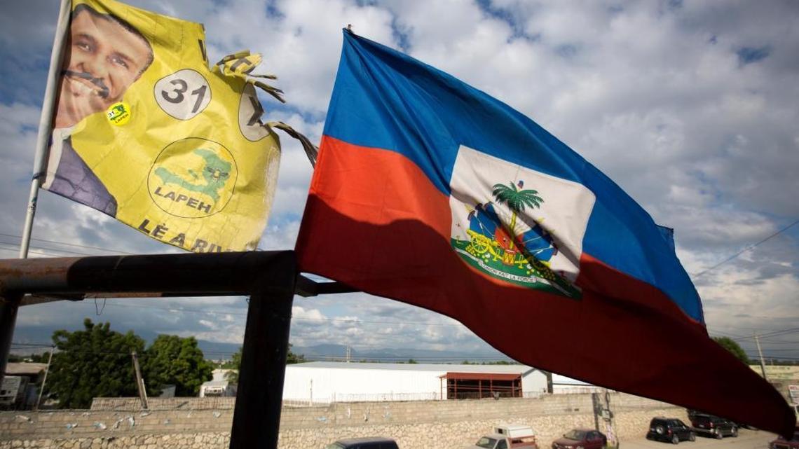 A campaign flag, right, of presidential candidate Jude Célestin flies next to Haiti's national flag on a street in Port-au-Prince, Haiti. Célestin finished 2nd last year in the opening round of the presidential election, which was later annulled amid accusations of fraud. He is now one of 27 candidates vying to lead Haiti for the next five years in an election redo set for Nov. 20.