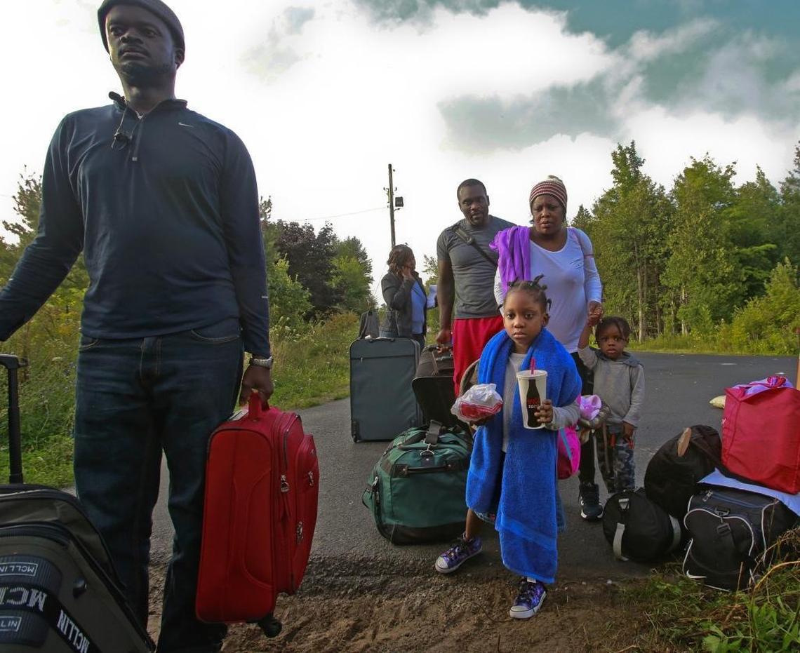 Haitian migrants prepare to cross illegally into Canada at the border along Roxham Road in Champlain, N.Y. on Sunday, August 13, 2017. They said fear of deportation under the Trump administration drove them to leave the U.S.