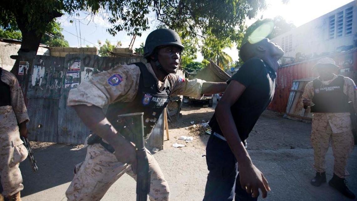 A police officer arrests a supporter of presidential candidate Jude Celestin during a protest against official preliminary election results announced by the Electoral Council in Port-au-Prince, Haiti, Friday Nov. 6, 2015. Celestin, a former state construction chief, and government-backed candidate Jovenel Moise, appear to be advancing to a runoff election for Haiti's presidency, according to preliminary results announced Thursday.