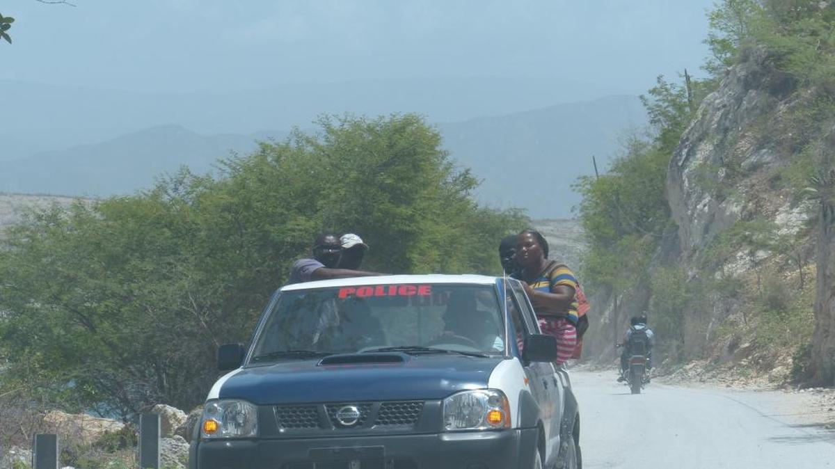 
Passengers hop a ride along the road connecting the border towns of Malpasse on the Haitian side and Jimani in the Dominican Republic aboard a Haitian National Police truck. Haitian authorities sent additional police officers to the border recently to ensure safe passage for Dominican truckers. 
