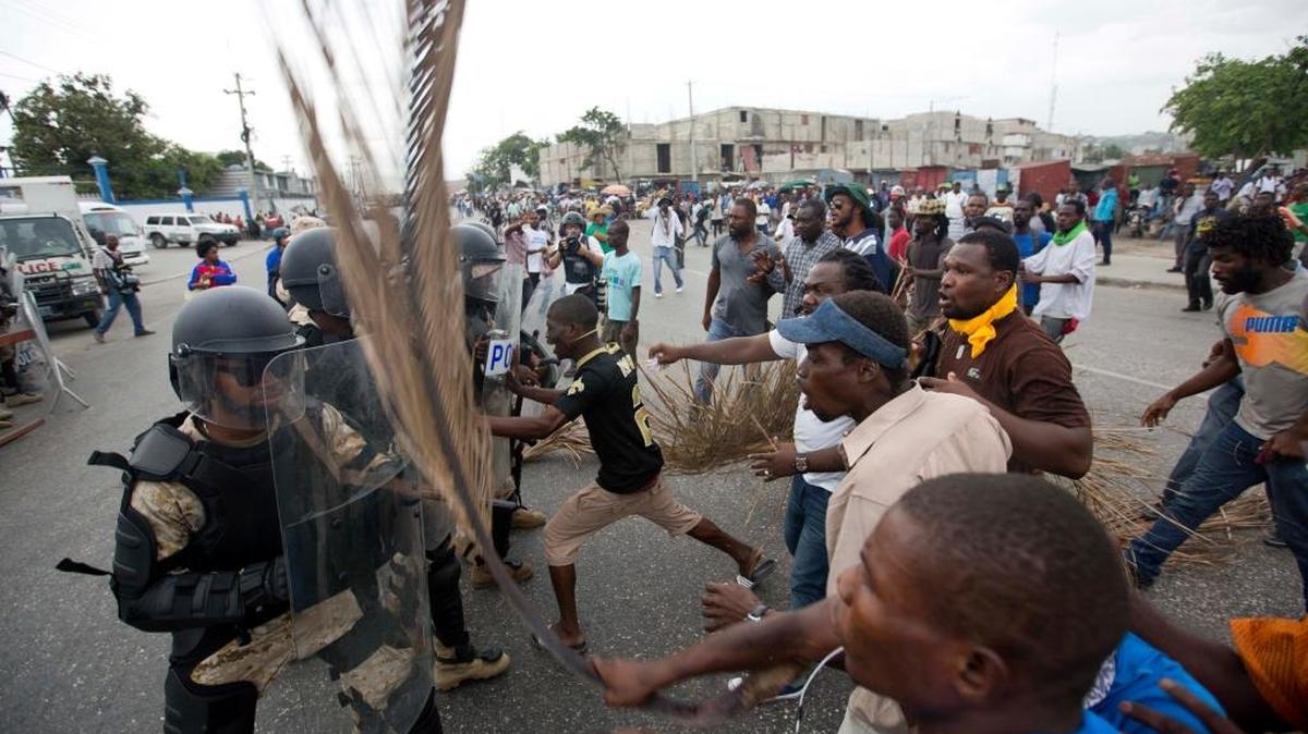 Supporters of presidential candidate Maryse Narcisse clash with national police officers close to the entrance of the parliament building during a demonstration in support of interim President Jocelerme Privert, in Port-au-Prince, Haiti, Tuesday, June 21, 2016. The demonstrators march to demand the extension of the expired mandate of the interim president Jocelerme Privert.