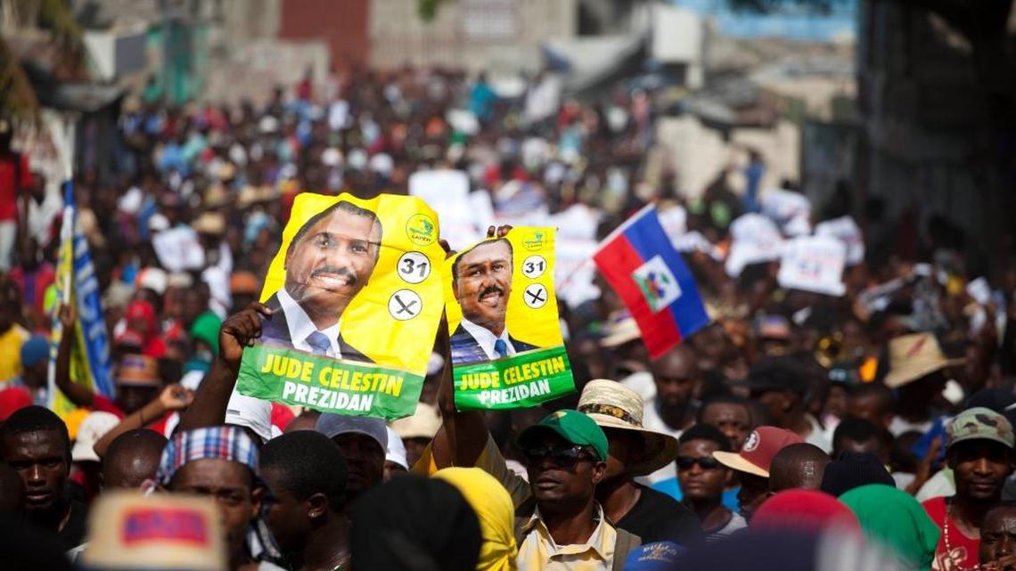 Protesters hold up election posters promoting presidential candidate Jude Celestin of the Lapeh party, during a protest against official preliminary election results, in Port-au-Prince, Haiti, Wednesday, Nov. 11, 2015. Haitian political parties Lavalas, Lapeh, and Platform Pitit Dessalines, have joined to demand the cancellation of the recent presidential election, or removal of ruling party candidate Jovenel Moise who is set to face Celestin in the Dec. 27 presidential runoff election.