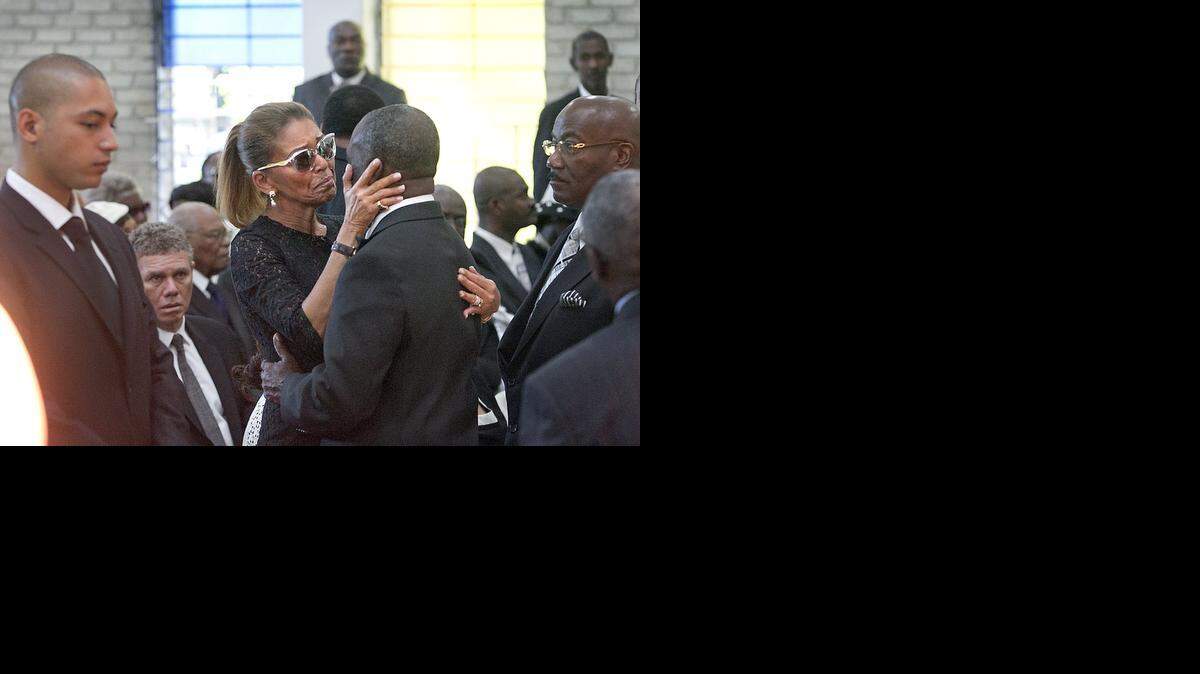 
Alongside her son Francois Nicolas Duvalier, left, Michele Bennett, the ex-wife of former Haitian dictator Jean-Claude “Baby Doc” Duvalier, gets a hug from Colonel Joseph Baguidy, who was having breakfast with Duvalier when he died. The morning funeral for the former Haitian dictator was held at the Chapelle Saint Louis de Gonzague in Port-au-Prince, Haiti, on Saturday, Oct. 11, 2014.
