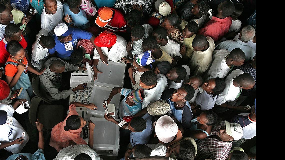 
In 2010, voters form lines in all direction as they stand surrounding election workers demanding the right to vote. Thousands of Cite Soliel residences gathered at 5 am to vote at the former state employee housing known as Building 2004 in Port-au-Prince, Haiti. 

