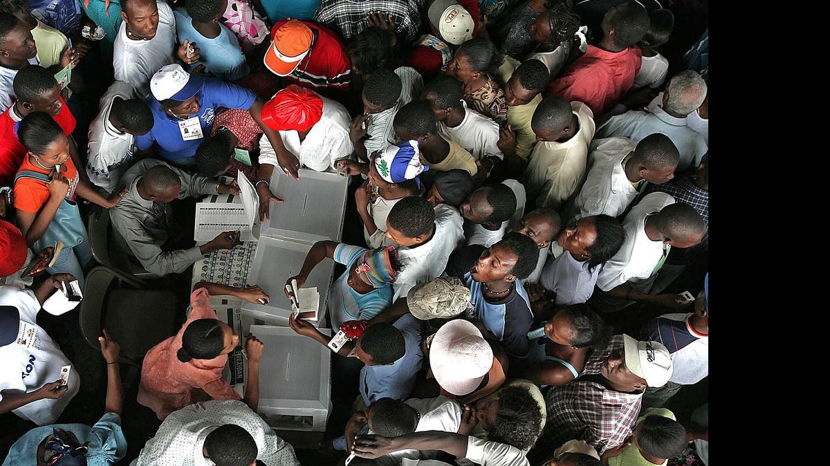
In 2010, voters form lines in all direction as they stand surrounding election workers demanding the right to vote. Thousands of Cite Soliel residences gathered at 5 am to vote at the former state employee housing known as Building 2004 in Port-au-Prince, Haiti. 
