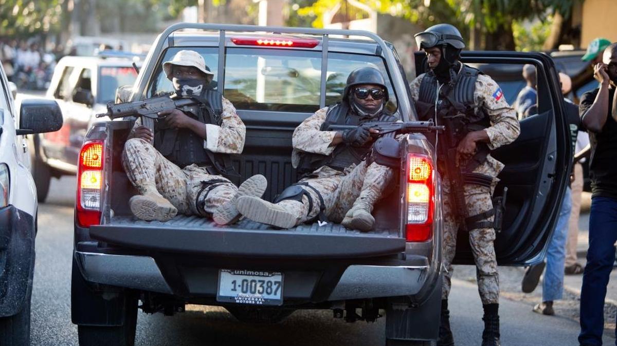 Haiti National Police patrol outside a radio station after the arrest of Guy Philippe in Petion-Ville, Haiti, Thursday, Jan. 5, 2017. The former rebel leader who is wanted on U.S. drug charges, and was recently elected to the Haitian Senate, was arrested Thursday as he appeared on a live radio talk show.